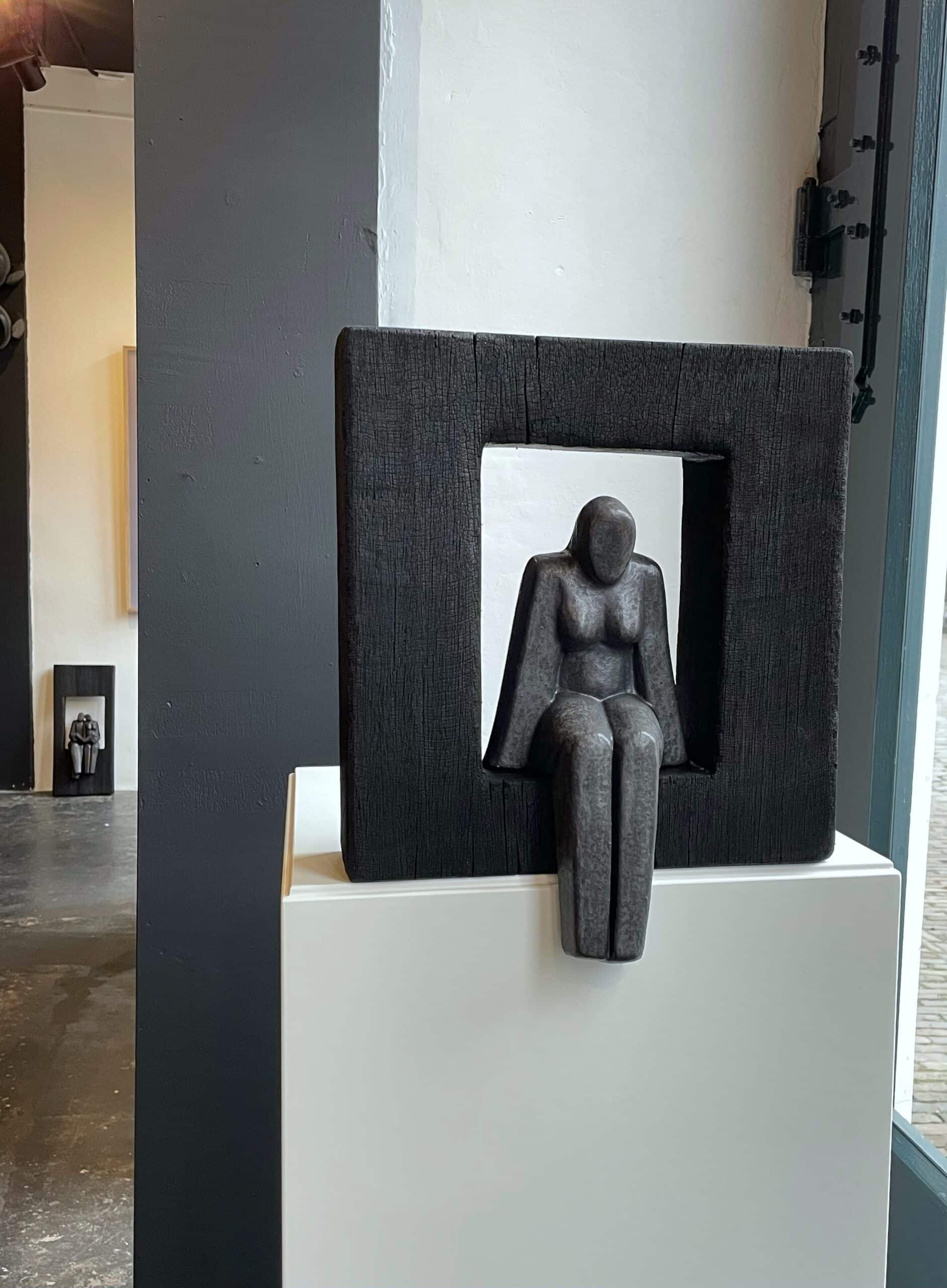 Zittende Vrouw in zwarte houten omlijsting